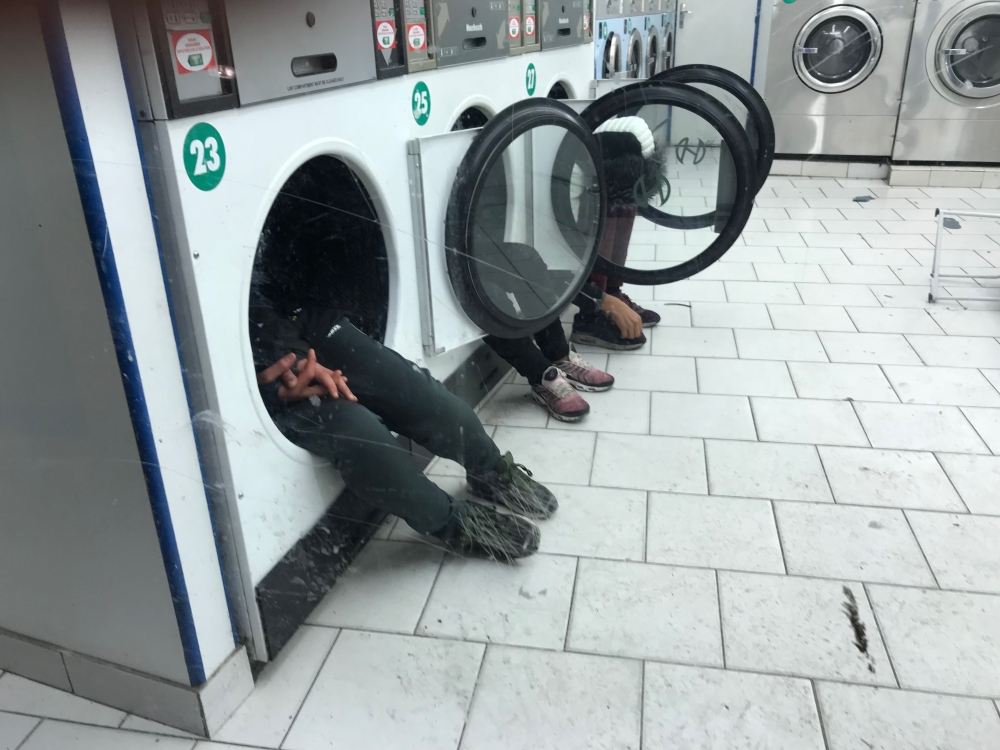 Migrants taking shelter in a Parisian launderette