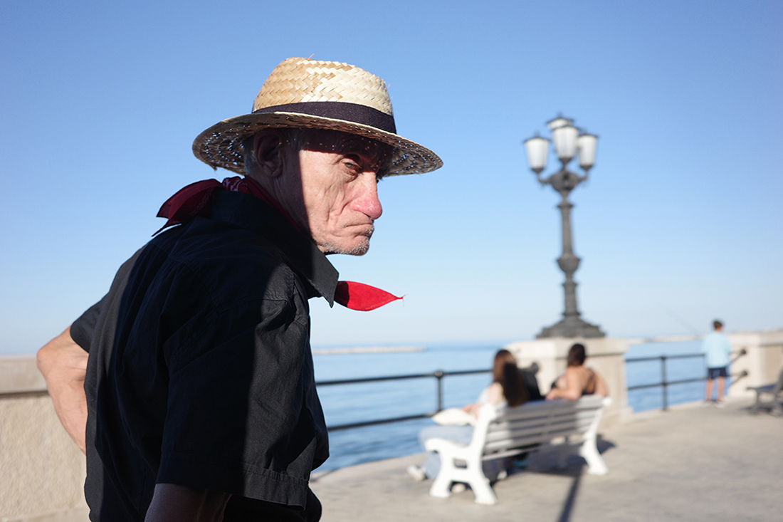 the man with the straw hat and the red scarf